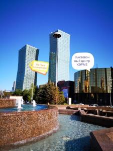 uma fonte em frente a uma cidade com edifícios altos em The Place Astana Hostel em Astana