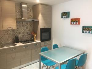 a kitchen with a blue table and blue chairs at Porto di mare luxury home in Giovinazzo