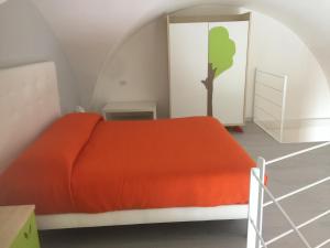 a bedroom with an orange bed and a tree on the wall at Porto di mare luxury home in Giovinazzo
