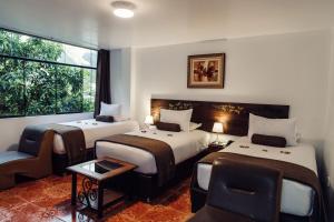 a hotel room with two beds and a window at Hotel Retama Machupicchu in Machu Picchu