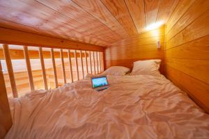 a bedroom with a bed with a laptop on it at Le Moulin in Martres-Tolosane