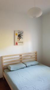 1 cama con cabecero de madera en una habitación en Chalet la barrosa a 800 mts playa, en Chiclana de la Frontera