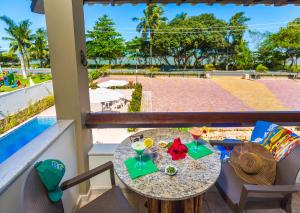 una mesa y sillas con bebidas en el balcón en Quinta do Sol Lite Praia Hotel, en Porto Seguro