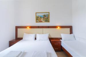 a bedroom with two beds and a painting on the wall at Chrissafis Hotel in Panagia