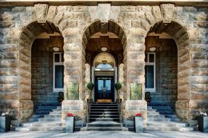 - un bâtiment en pierre avec des escaliers menant à une porte dans l'établissement Adina Heritage Christchurch, à Christchurch