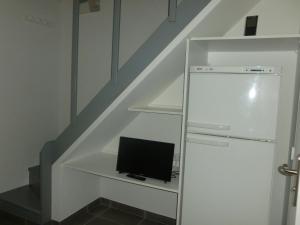 un ordinateur installé sur une étagère sous les escaliers dans l'établissement Mini villa au bord de la mer, proche Moriani (Corse), à Poggio-Mezzana