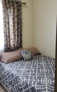 1 cama con edredón azul y blanco en un dormitorio en Manila Bay- - Breeze Residences en Manila