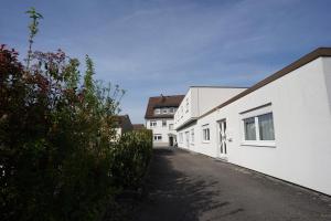an alley between two white buildings on a street at Hotel Sauer Garni in Neu Isenburg