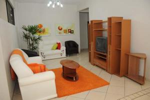 a living room with a white couch and a tv at HOTEL MICHELS in Candelária