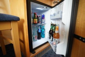 an open refrigerator filled with lots of drinks at Hotel Sauer Garni in Neu Isenburg