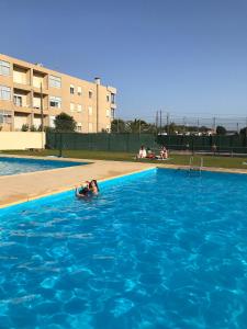 a woman is swimming in a swimming pool at Sunny Beach Apartment Holidays in Vila do Conde