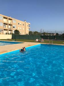 a woman is swimming in a swimming pool at Sunny Beach Apartment Holidays in Vila do Conde