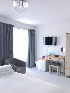 a bedroom with a bed and a chair and a desk at Prestbury Bed & Breakfast in Salisbury