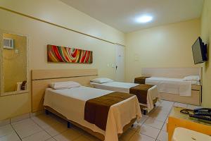 Habitación hospitalaria con 2 camas y TV en Villa Neves Residence, en Belo Horizonte