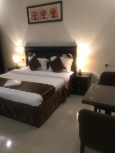 Habitación de hotel con cama y silla en Top Stars Hotel en Al Ḩanākīyah