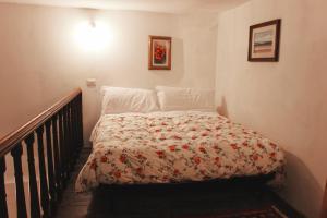 a small bedroom with a bed with a flowered blanket at Mimi's studios in Venice