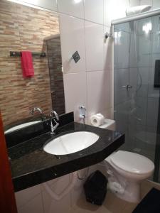 Un baño con lavabo, inodoro y ducha. en Pousada Bontempo, en Pirenópolis