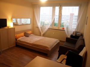 ein Schlafzimmer mit einem Bett, einem Stuhl und einem Fenster in der Unterkunft Apartment Rochstrasse Berlin in Berlin