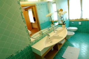 y baño con lavabo, aseo y espejo. en Alphotel Taller Wellness & Sport, en Folgarida