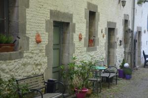 Ragnies的住宿－La Gentilhommière du Château de Ragnies，一条长凳和桌子的小巷以及一座种植了植物的建筑