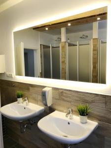 ein Badezimmer mit zwei Waschbecken und einem großen Spiegel in der Unterkunft Blue Doors Hostel KTV in Rostock