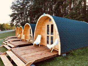 a group of huts with chairs and a deck at Luxury Camping POD in Zarasai +17 photos