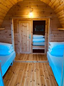 a room with two beds in a log cabin at Luxury Camping POD in Zarasai