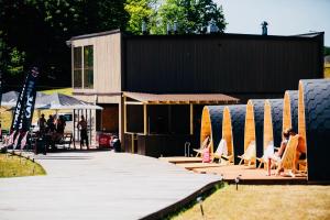 a group of chairs and umbrellas next to a building at Luxury Camping POD in Zarasai