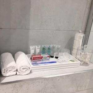 a shelf in a bathroom with towels and toothbrushes at Prestbury Bed & Breakfast in Salisbury