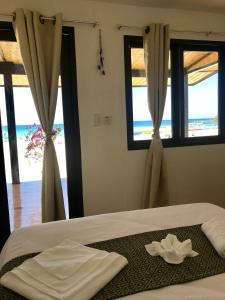 a bedroom with a bed with a view of the ocean at Fisherman's Cottage El Nido in El Nido