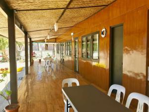 a dining room with a table and white chairs at Fisherman's Cottage El Nido in El Nido