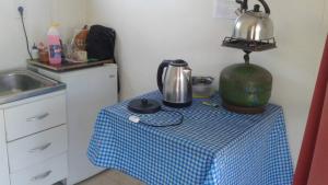 a kitchen with a table with a tea kettle on it at Hostal Posada Del Hum in San Gregorio de Polanco