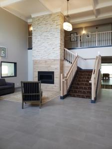 a lobby with a staircase and a fireplace at Country Inn & Suites by Radisson, Detroit Lakes, MN in Detroit Lakes