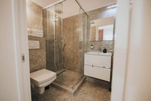 a bathroom with a shower and a toilet and a sink at Hotel Marabella in Sibiu