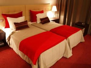 una habitación de hotel con una gran cama roja y blanca en Hotel Dighton, en Oliveira de Azemeis