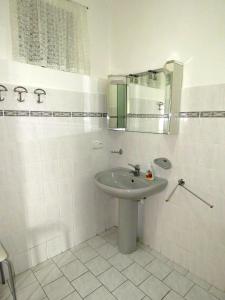 Baño blanco con lavabo y espejo en Penzion Severka, en Rokytnice v Orlických horách