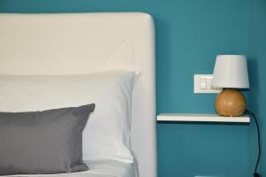 a bed with a lamp on a blue wall at B&B Albatros Centro Storico Palermo in Palermo