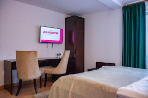 a hotel room with a bed and a television at Hotel THR Center in Curtea de Argeş