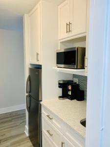 uma cozinha com armários brancos e um frigorífico preto em Bayside Retreat em Ruskin