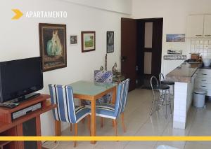 a kitchen with a table and chairs and a television at Atlantic City Apart Service in Salvador