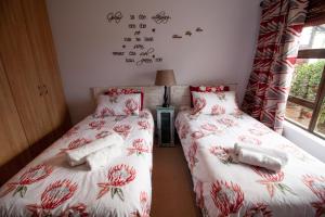 two twin beds in a room with writing on the wall at Froggy Bay is the best all the way! in Simonʼs Town