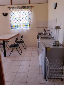 cocina con fregadero y mesa con sillas en APARTHOTEL Santa Maria, en Punta de Choros