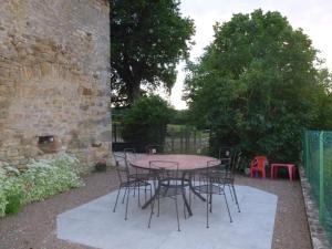 - une table et des chaises dans une cour avec un bâtiment en briques dans l'établissement Gîte du Charmoy, à Clomot