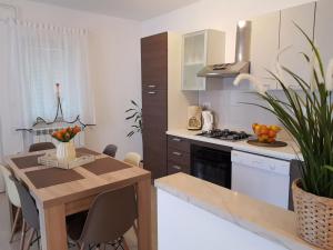 a kitchen with a wooden table and a counter top at Apartman Ruza 1 in Poljane