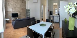 uma sala de estar com uma mesa e um sofá em Carmo House em Braga