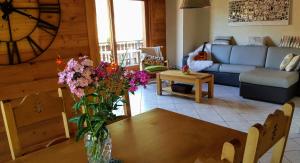 una sala de estar con un jarrón de flores sobre una mesa en Les Picaillons - Le gîte en Les Villards-sur-Thônes