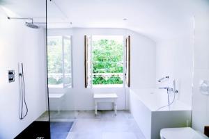 a white bathroom with a shower and a sink at GLYCINES COUNTRY GUESTHOUSE in Goupillières