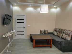 sala de estar con sofá y mesa en Golden Apartments, en Khujand