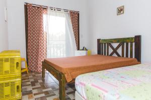 - une chambre avec 2 lits et une fenêtre dans l'établissement Villa Johen, à Boicucanga
