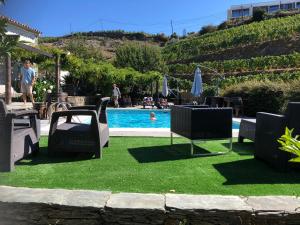 
a lawn chair sitting in front of a pool of water at Quinta da Casa Cimeira, Guest House, Wines & Food in Valença do Douro
